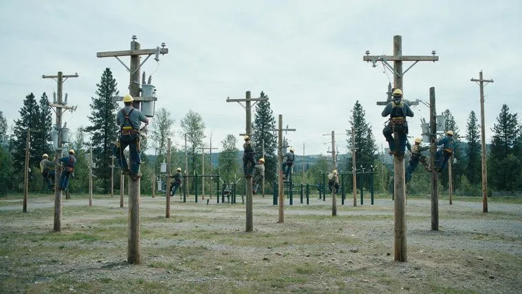 Turma de eletricistas em prática em postes de treinamento