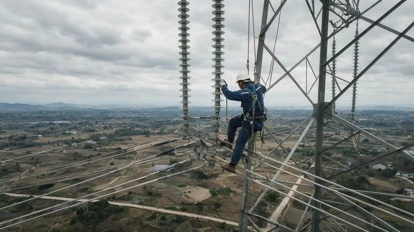 Trabalho em torre de transmissão de alta tensão com linha energizada